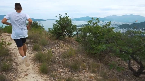 Running man exercising on mountain forest trail at sunset Stock Footage 76488217