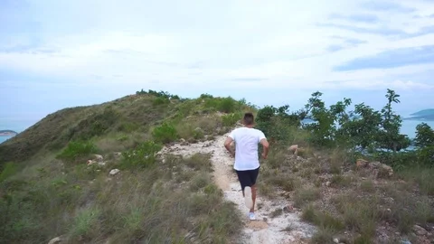 Running man exercising on mountain forest trail at sunset. Stock Footage 76510299