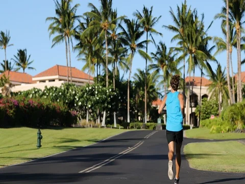 Running man jogging on road exercising on residential street on summer day Stock Footage 76801899