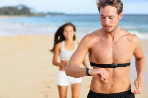 Running man jogging using heart rate monitor Stock Photos