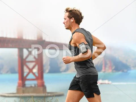 Running man - male runner in San Francisco listening to music on smart phone Stock Photos