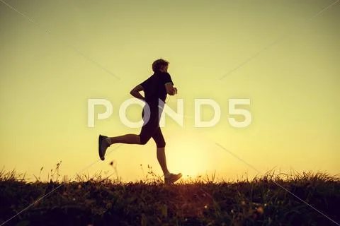 Running man silhouette in sunset time Stock Photos