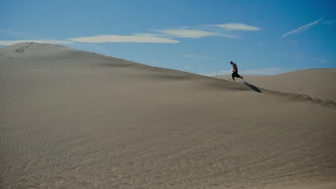 Running man throw desert maspalomas Stock Footage 167162931