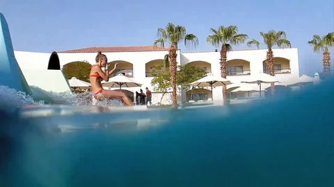 Running into pool from water slide in slow motion Stock Footage