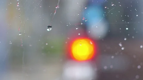 Running raindrops on car window over taillight Stock Footage 79051191