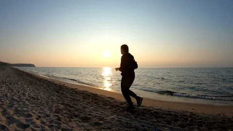 Running on the sandy beach at sunset Stock Footage 108474384