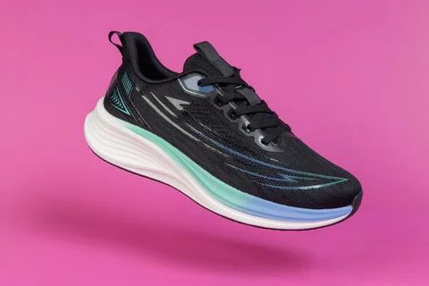 Running shoe levitating on pink background. Modern athletic footwear for fi.. Stock Photos