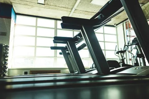 Running simulators in the gym interior opposite the window. Empty fitness rooms Stock Photos