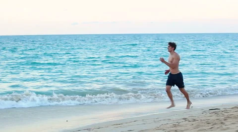 Running sport man jogging on beach Stock Footage 54144928