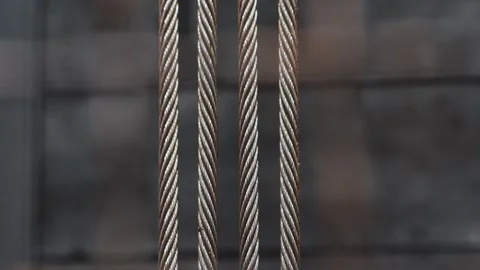 Running steel cables lowering an elevator car, yellow paint intermittently Stock Footage 138338723