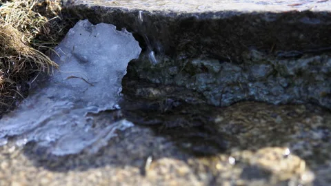 Running streams of cold clean water through thawed snow over rocks. Stock Footage 88823315