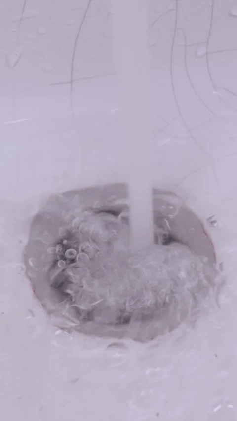 Running water flows down a white sink drain and stops completely Stock Footage 330404977