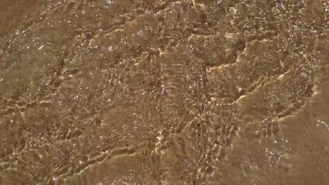 Running water over sand beach with flecks of sunlight. Slow motion 스톡 동영상 72706702