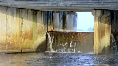 Running water in the river dam in summer. Water drops in the concrete and metal Stock Footage 65913639