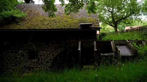 A running watermill wheel driven by water at an abandoned mill house in Germany Video stock 312443694