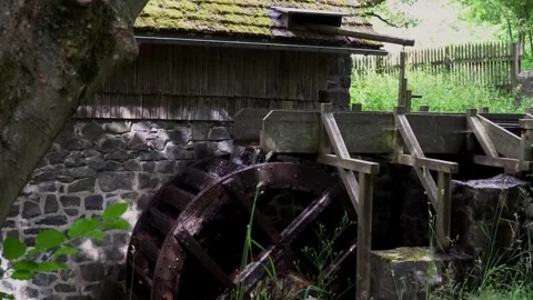 A running watermill wheel driven by water at an abandoned mill house in Germany Video stock 312443715