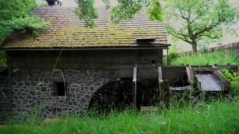 A running watermill wheel driven by water at an abandoned mill house in Germany Video stock 312443741