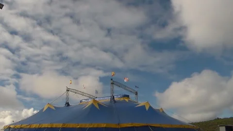 Running white clouds in blue sky background over circus tent. Stock Footage 92556940