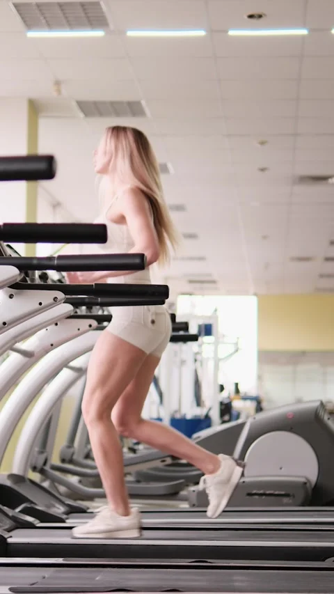 Running woman practicing on treadmill machine in fitness gym. Slow motion. Stock Footage 265172622
