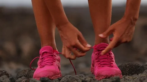 Running woman tying shoe laces going running - girl trail runner Stock Footage
