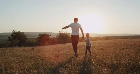 Running young dad with his three years old son, at sunset , amazing view. Video stock 96109414