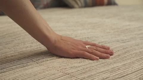 Runs his hand over the bedspread on the bed Stock Footage 275170682
