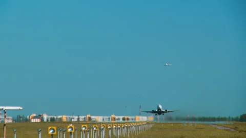 Runway with an airplane taking off and simultaneously the board preparing to lan Stock Footage 92235407