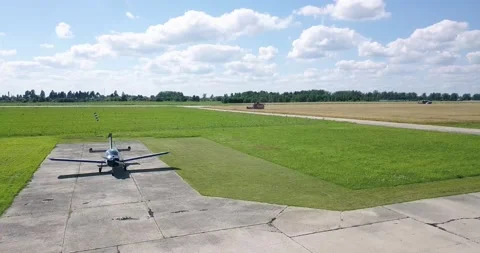 On the runway there is an old maize plane, a combine is working behind it, a Video stock 138035192