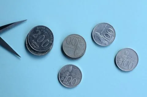 Rupiah Decrease Concept. Rupiah coins and scissors. Coins with blue background 스톡 사진