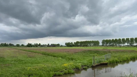 Rural Amsterdam, Low storm clouds over Dutch farmland beside canal in rural Stock-Footage 342752763