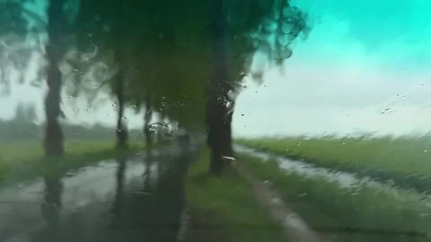 Rural Amsterdam, Rain-smeared windshield view of rural road with blurred car Stock-Footage 342750341