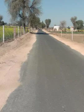Rural Asphalt Road Through Fields in 9KD Rajasthan India Stock Photos