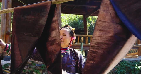 A rural authentic hand made fabric manufacturer hanging her fabric in the sun, A Stock Footage 201096246