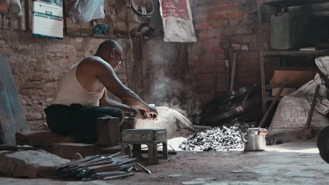 Rural blacksmith starting fire in smithy furnace Stock Footage 164532484