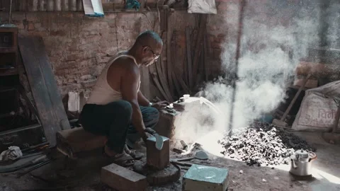 Rural blacksmith worker adding coal to furnace fire Stock Footage 164192957