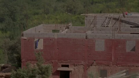 A rural building under construction blends traditional earthen walls with Vídeos de archivo 346106410