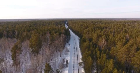 A rural desert road surrounded by a winter forest with a copter Stock-Footage 74744966
