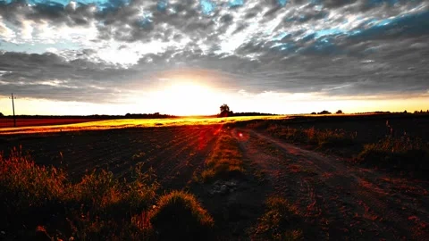 Rural Dirt Road at Dramatic Sunset Over Farmland 動画素材 335659408