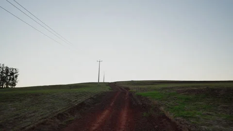 Rural dirt road through open farmland under a vast sky Stock-Footage 335689245