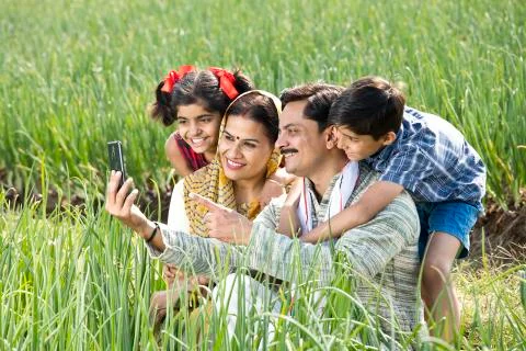 Rural family taking selfie using mobile phone on agriculture field Stock Photos