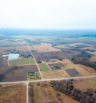 Rural Farmland with Patchwork Fields and Small Pond in Overcast Light 스톡 사진