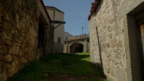 Rural footpath winding between ancient stone buildings Stock Footage 335463135