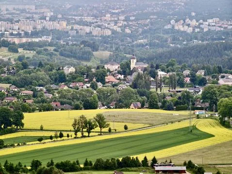 Rural hillside village with patchwork fields and distant city skyline Stock-Fotos
