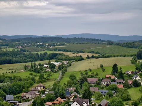 Rural hillside village with patchwork fields, orchards and scattered farm b.. Stock Photos