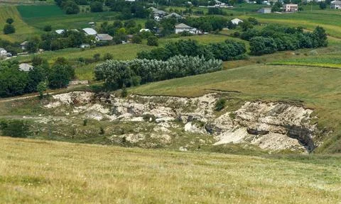 Rural landscape with eroded limestone cliffs and distant village houses in .. Stock-Fotos