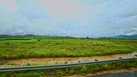 Rural Landscape Fields Grass Road Barriers against Cloudy Sky 스톡 동영상 76554927