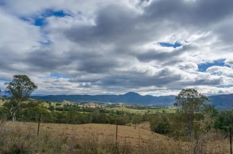 Rural landscape with paddock fields and distant mountains, hills Foto stock