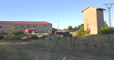 Rural landscape panning over an old abandoned farm building Видео 344043738