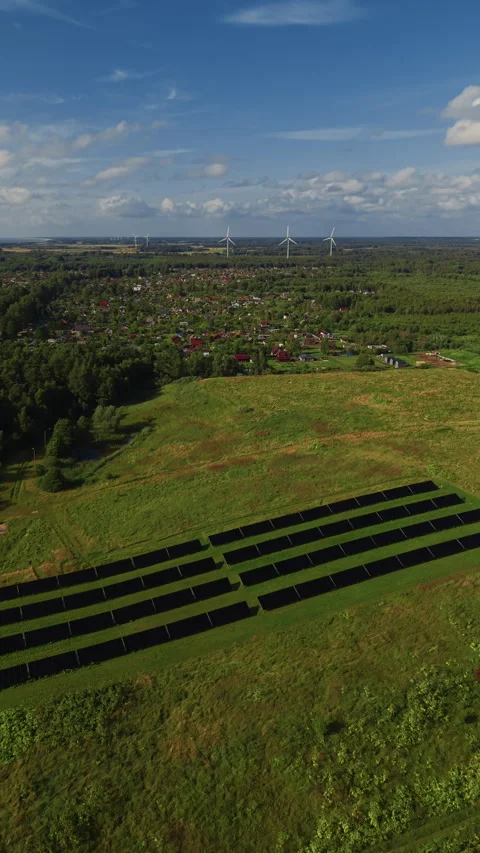 Rural landscape with solar panel field, village houses and wind turbines under Stock Footage 344665604