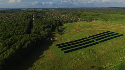 Rural landscape with solar panels, forest, village homes and wind turbines under Stock Footage 344662167
